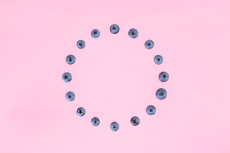 Berries of blueberries arranged in a circle. pink background. Concept of berries season and proper nutrition. flat lay. copyspace.の写真素材