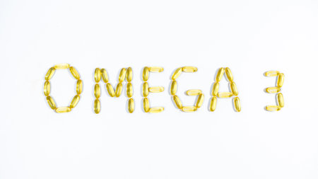 Word OMEGA 3 lined from yellow transparent capsules with fish oil. white background. Maintaining and improving health.の写真素材