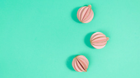 Pink balls to decorate the Christmas tree on a green background. Beautiful holiday frame. Copy...