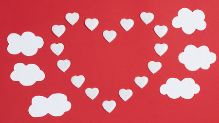 Small hearts appears one big heart shape with copy space in center. Near white clouds. Greeting...