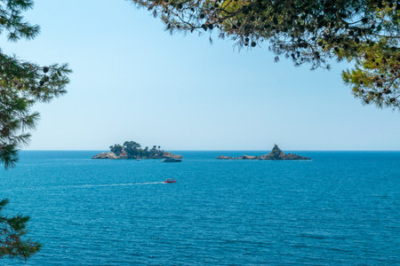 Tiny little islands with a lonely building and a few pine trees near the Sveti Stefan. Boats and yachts near the islands. Montenegro. Adriatic Sea Montenegro.の写真素材