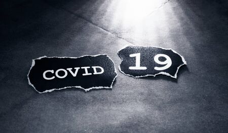 Close up of a COVID-19 text tag on paperの写真素材