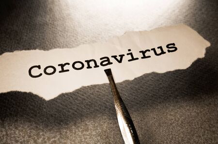 Close up of a COVID-19 text tag on paperの写真素材