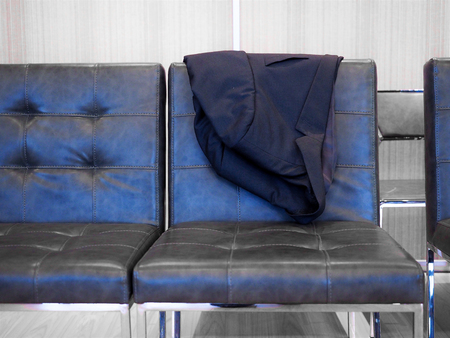 Black suite on the leather chair.の写真素材