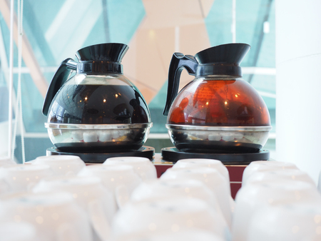 Coffee pot and tea pot  on hot stove with white cup.の写真素材