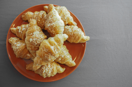 A group of croissant on orange plate.の写真素材