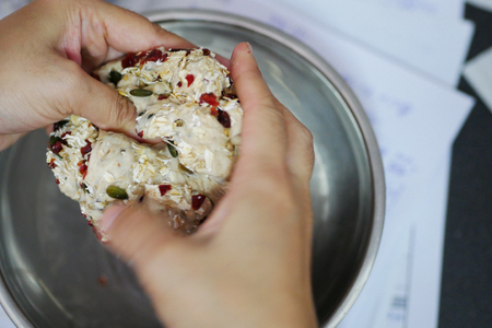 Hands kneading dough of multigrain bread.の写真素材