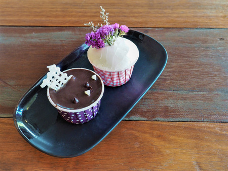 Two cupcakes on black plate.の写真素材