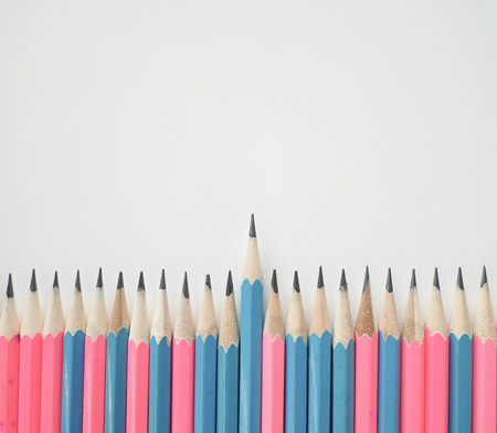 Pink and blue pencils lining with one outstanding in the middle.の写真素材