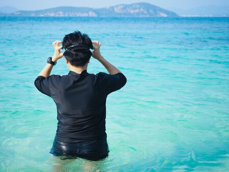 Swimmer in black suit get ready for swim in the sea.の写真素材