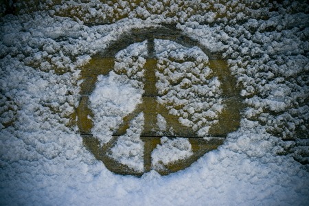 A peace signed written in the snow on an old vintage tableの写真素材