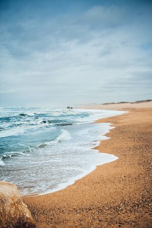 Waves on sandy beach near Porto, Portugalの写真素材