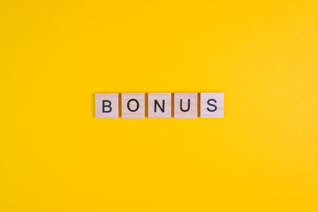Word Bonus formed by wooden letters on orange background. Top view. Copy spaceの写真素材
