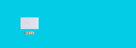 White envelope with mail written formed by wooden letters on a blue background. Top view. Banner....