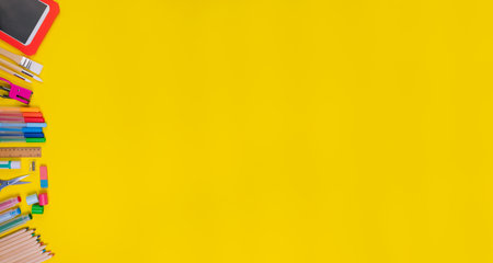 Set of school items on the left of the orange background. Back to school concept. Top view. Banner. Copy spaceの写真素材