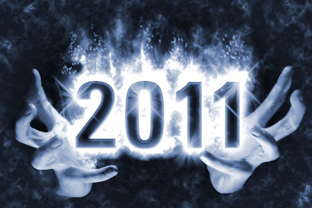 Happy New Year background with effect of cast magic spell, blue energy flames wrapping around digits 2011 in the dark glowing between handsの写真素材