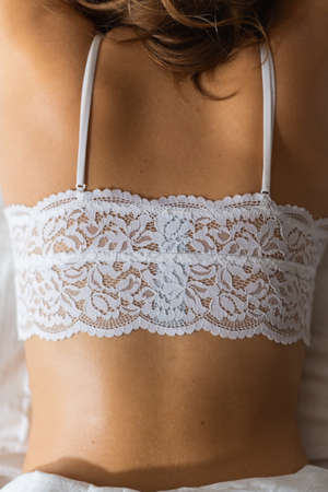Young woman wearing white lace brassiere close-up. Top down perspective.の写真素材