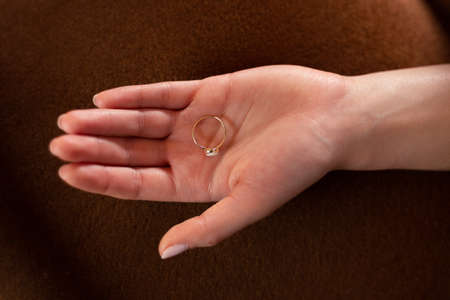 Golden ring laying on an open hand of a woman, Horizontal photo.の写真素材