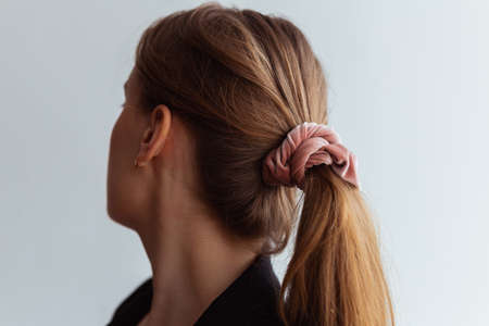 Close-up of a baby pink scrunchie, natural blonde young woman,の写真素材
