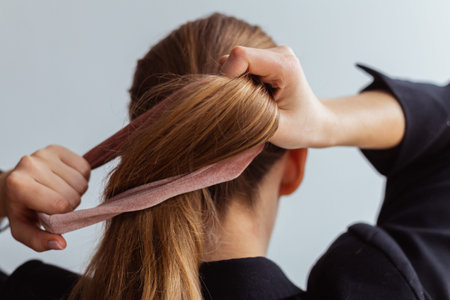 Natural blonde woman doing a ponytail, holding her hair, stop motion, back view,