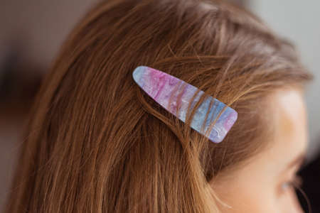 Close up of a cute, girly hair clip with an universe theme on it, blonde hairの写真素材