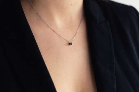 Close-up of silver necklace with black stone pendant on woman's neck, elegant style, business power woman, successful peopleの写真素材