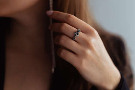 Silver rose ring on a middle finger of a young blonde lady. Close-up.の写真素材