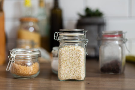 Small glass jar with sesame seeds, ingredients, kitchen equipment, vegetarian food, nutrition,...