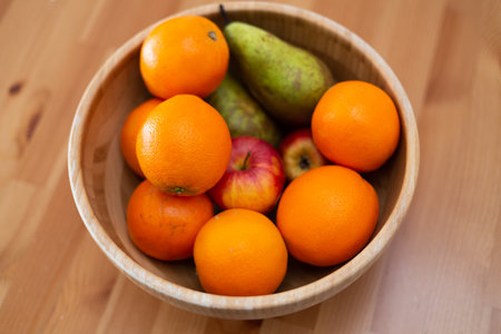 Wooden bowl with fresh fruits, oranges, apples and peaches, on wooden table, vegetarian meal, new trends, healthy food, nutrition, dietの写真素材