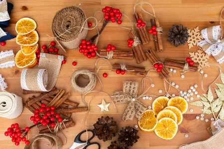 Top down view of adorable christmas decorations, DIY, handcraft activity, enjoying free time with family, many materials, bright environment, hobby, cinnamon, oranges, conesの写真素材