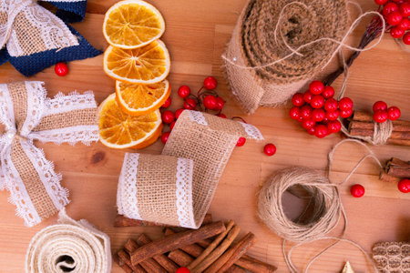 Top down view of rustic style handmade, diy, christmas, festive decorations, cinnamon sticks, dried oranges, wooden table, warm tones, banner, backgroundの写真素材