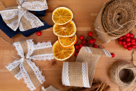 Christmas rustic style handmade decorations on wooden table view from the top, cords, oranges, bows, do it yourself, trendy, taking care of the environment, ecology, background, bannerの写真素材