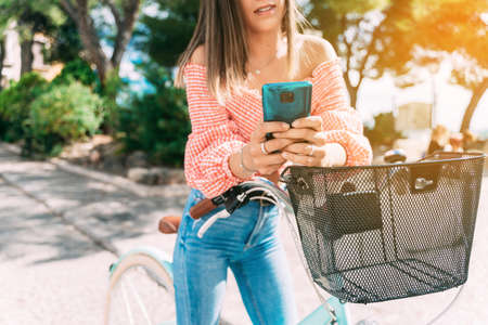 young woman on a bicycle chats with her mobile phoneの写真素材