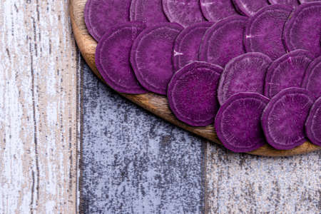 Foreground of the chopped sweet potato on the cutting board, background out of focus, healthy and ecological foodの写真素材