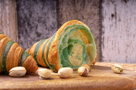 Photo of a traditional freshly baked croissant filled with a delicious pistachio cream.の写真素材