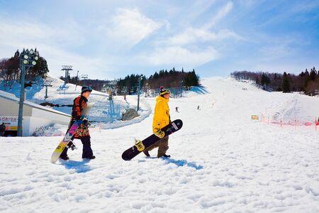 Yuzawa, Niigata, Japan - April 2017: Snowboarders walk with snowboard in hands.snowboarding concept. Gala Yuzawa ski resort.のeditorial素材