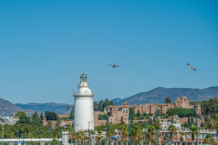 Famous Lighthouse of Malaga Port with Alcazaba on background. Costa del Sol. Spain.の写真素材