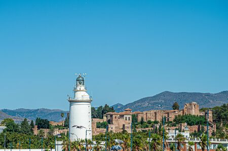 Famous Lighthouse of Malaga Port with Alcazaba on background. Costa del Sol. Spain.の写真素材