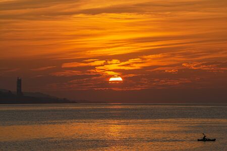 Beautiful orange sunrise with canoe in the Malaga Port. Andalusia. Spainの写真素材