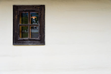 Old white wall with a wooden window
