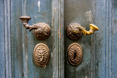 Door handles with an old double door painted with blueの写真素材