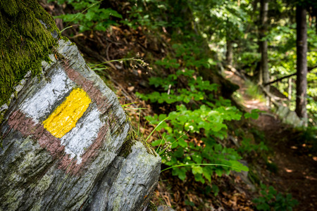 Touristic sign  on stone next to touristic pathの写真素材