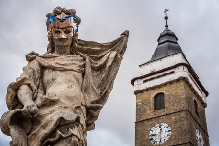 Granite statue of Virgin Mary with church towerの写真素材