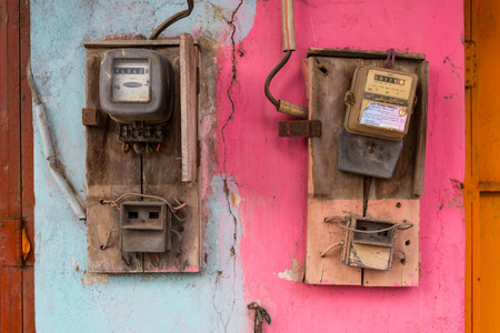 Two old colorful electric meters on the wallの写真素材