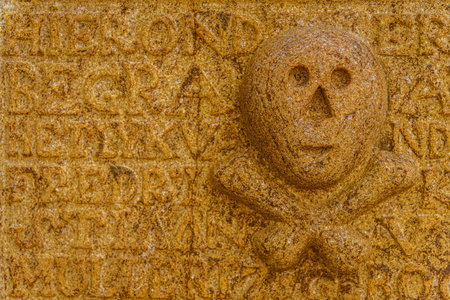 Skull and bones at an antique and weathered tombstoneの写真素材