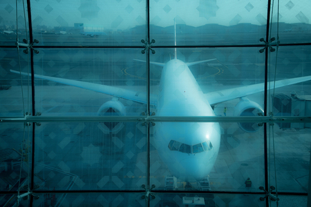 Airplane behind glass at the airportの写真素材