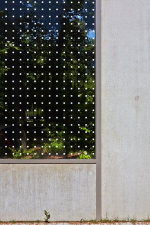 Concrete wall with a window on the greenの写真素材