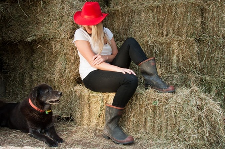 Girl with dog in hay barn の写真素材