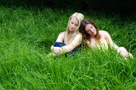 Girls resting in the field in the sun and the long grassの写真素材