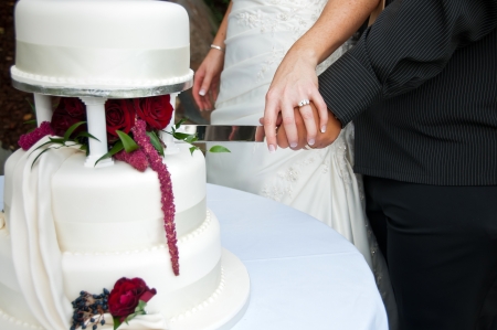 Bride and groom cutting wedding cakeの写真素材